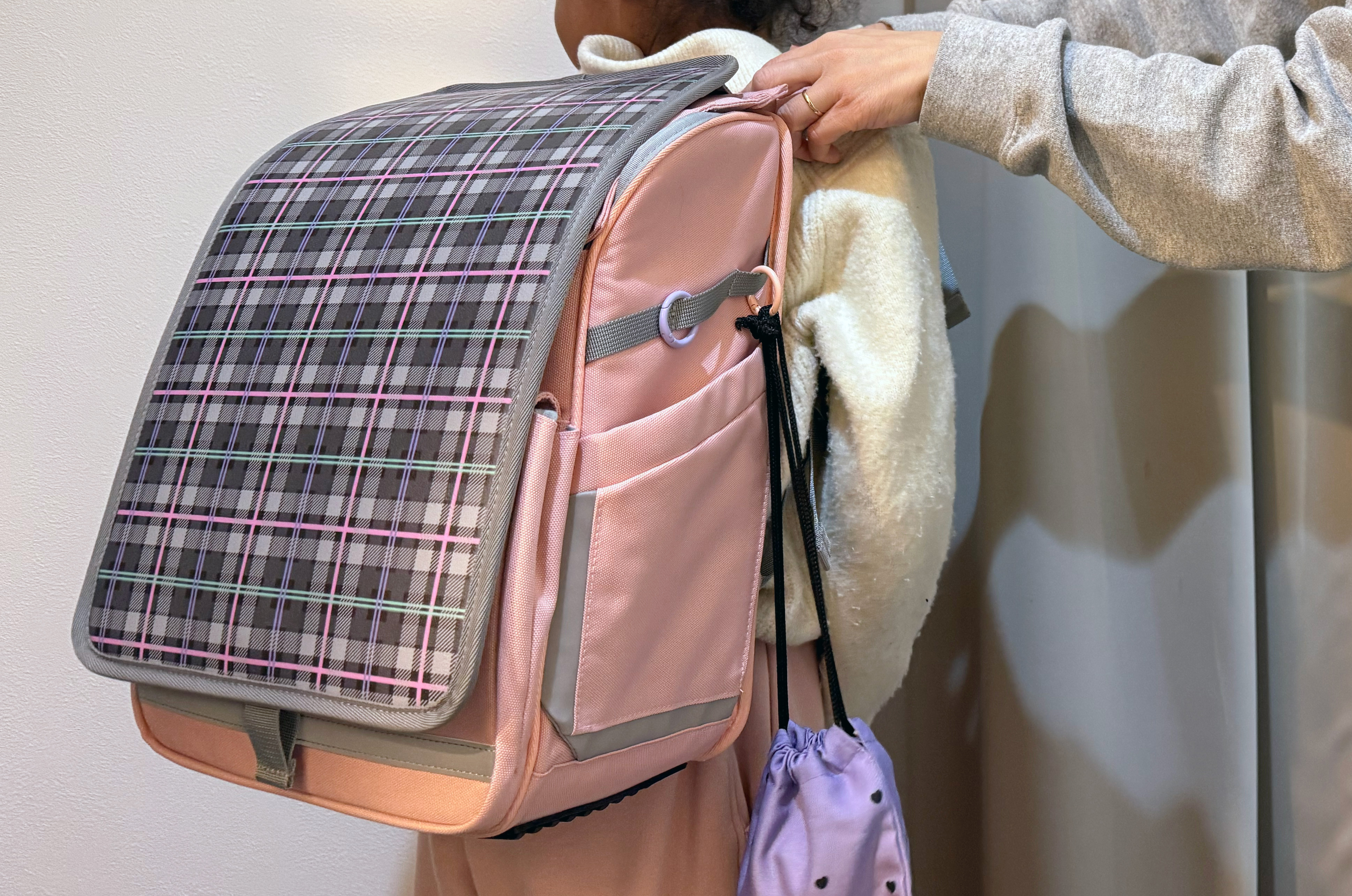 ぴったセルを背負った女の子と家族の写真